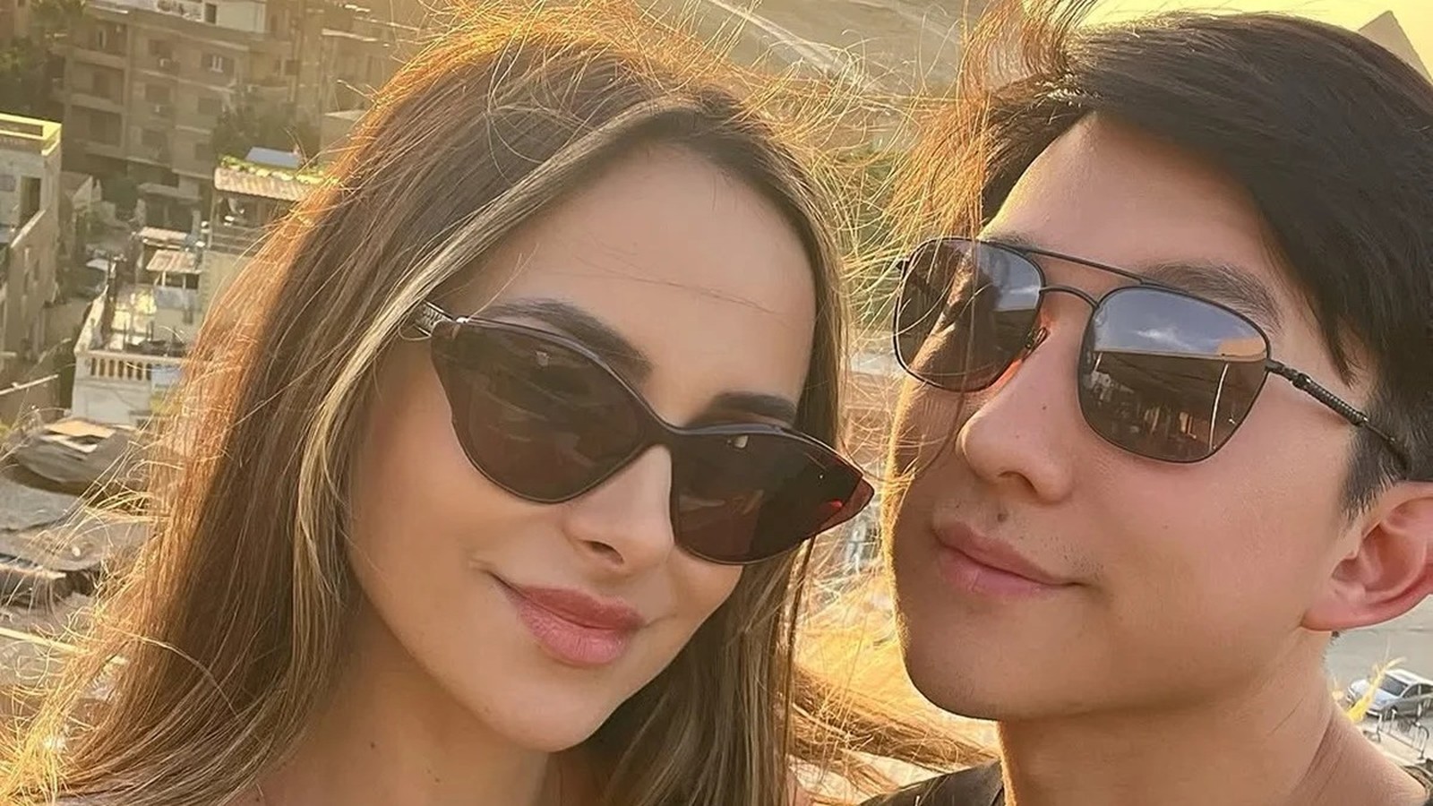 Pyong Lee e Natália Nasser, de óculos escuros, sorrindo em um registro de perto