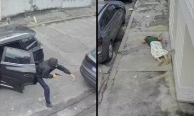 Homem armado saindo de veículo preto e mulher caída no chão após assalto