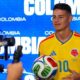James Rodríguez em camisa amarela da Colômbia número 10, segurando bola de futebol Adidas Brazuca