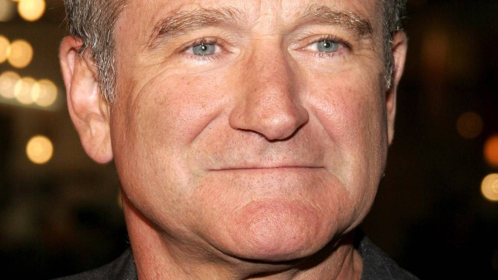 Close-up do rosto de Robin Williams com olhos azuis e cabelos grisalhos