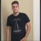 Homem jovem, Gabriel Dias Fernandes, cabelo e barba escura, vestindo camiseta preta com estampa de barco