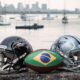 Capacete preto Ravens, capacete cinza Cowboys e bola do Brasil com baía ao fundo