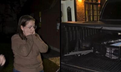 Mulher de óculos, mãos no rosto, chocada; ao lado, caçamba de picape preta vazia com caixa