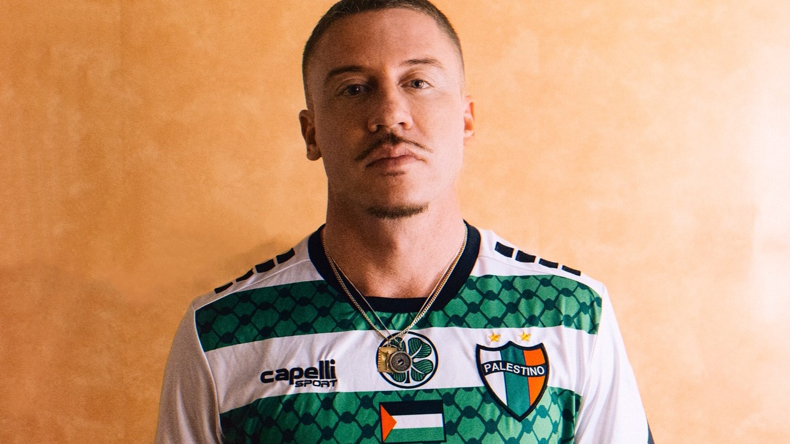 Rapper Macklemore, camisa de futebol branca e verde com logo PALESTINO no peito