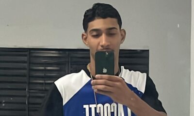Jovem masculino tira selfie no espelho, segurando smartphone, usa corrente dourada