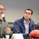 Três homens em reunião, um falando ao microfone, com bola de futebol americano Wilson The Duke Rio