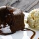 Petit gâteau de chocolate com recheio derretido e sorvete de creme em prato branco