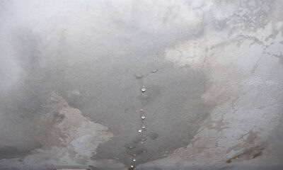 Teto de concreto com manchas de umidade e várias gotas de água pingando