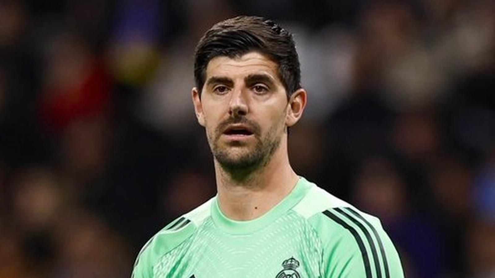 Thibaut Courtois, goleiro do Real Madrid, em close-up, vestindo camisa verde