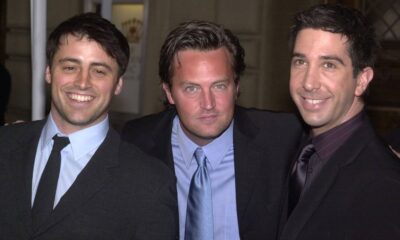Matt LeBlanc, Matthew Perry e David Schwimmer, sorrindo, em ternos escuros, posando.