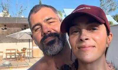 Juliano Cazarré, barbudo, e Leticia Cazarré, de boné, sorriem em selfie ao ar livre