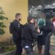 Policiais civis armados com coletes "POLÍCIA CIVIL" escoltam homens em frente a um prédio