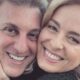 Close-up de mulher loira e homem grisalho sorrindo, faces próximas, mão toca rosto