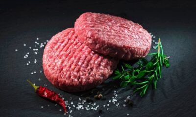 Duas hambúrgueres de carne crua com sal, pimenta preta, alecrim, tomilho e pimenta vermelha
