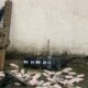 Fuzil, pistola, rádio, cinto tático com 'BX 21', e drogas em pacotes no chão