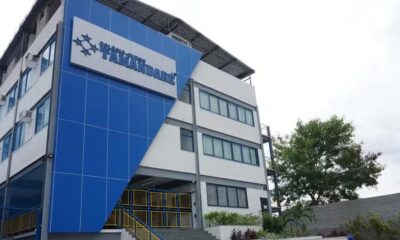 Edifício moderno com fachada azul e branca, placa "COLÉGIO-CURSO TAMANDARÉ", janelas e entrada com escadas