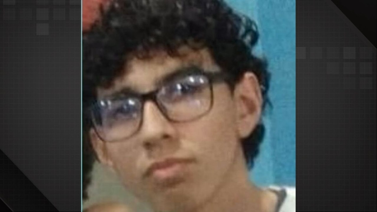 Close-up de jovem com cabelo escuro encaracolado e óculos, olhando para o lado