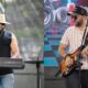 Dois músicos no palco, um tocando teclado, outro guitarra elétrica, durante apresentação