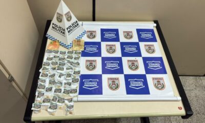 Dinheiro e dezenas de porções de crack em embalagens plásticas sobre uma mesa da Polícia Militar