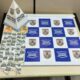 Dinheiro e dezenas de porções de crack em embalagens plásticas sobre uma mesa da Polícia Militar