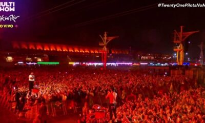 Concert noturno, palco iluminado, multidão Rock in Rio, logotipo Multi Show e hashtag Twenty One Pilots