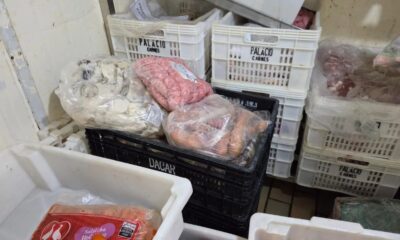 Sacos de carne em caixas de plástico brancas e pretas, com etiquetas 'PALÁCIO CARNES' e 'DACAR'