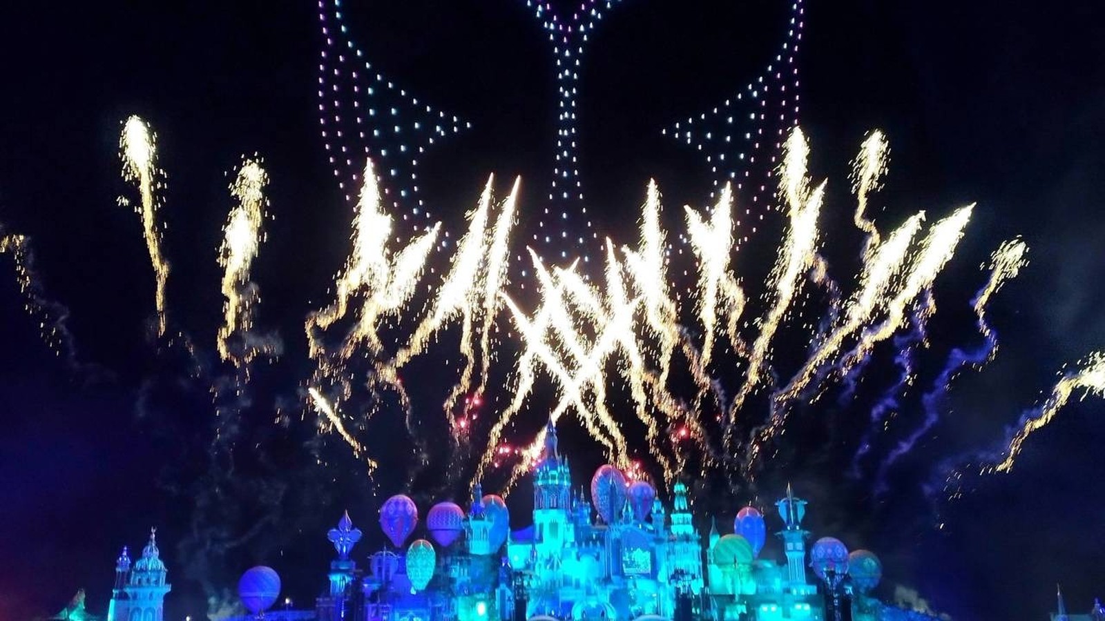 Fogos de artifício, drones luminosos e um castelo azul iluminam o céu noturno