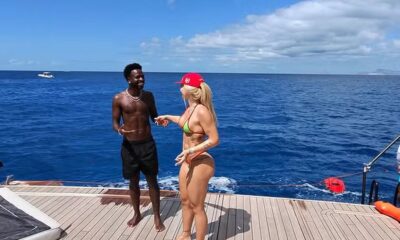 Vini Jr e Virginia em iate, conversando no mar azul sob céu claro