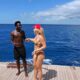Vini Jr e Virginia em iate, conversando no mar azul sob céu claro