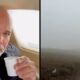 Cantor Rick em aeronave segurando copo, ao lado de paisagem encoberta por neblina densa