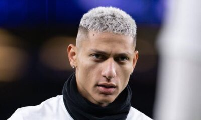 Rosto de Richarlison com cabelo curto platinado, brinco de diamante e cachecol preto