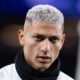 Rosto de Richarlison com cabelo curto platinado, brinco de diamante e cachecol preto
