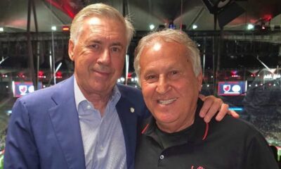 Carlo Ancelotti (esquerda) e Zico (direita) sorrindo em foto juntos, em um estádio