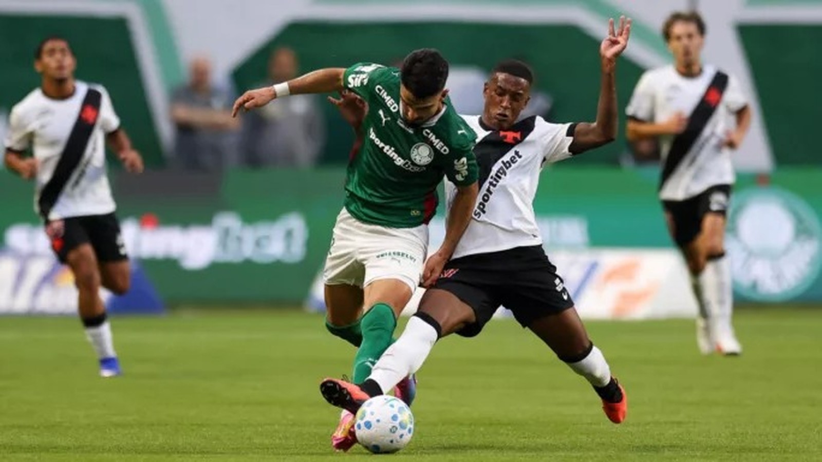 Dois jogadores, um do Palmeiras (verde) e um do Vasco (branco), disputam a bola em campo