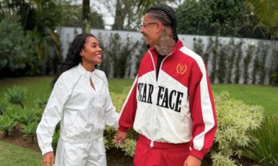Giovanna Jacobina e Breno Fagundes sorrindo de mãos dadas, ela de branco, ele de agasalho