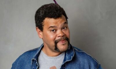 Ator Babu Santana, cabelo crespo com pente, bigode, cavanhaque, camiseta cinza, jaqueta jeans