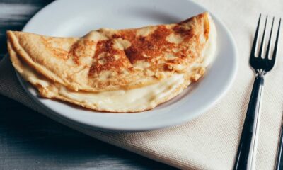 Crepioca dobrada com recheio claro e cremoso em um prato branco, com talheres