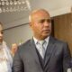 Mulher de noiva, homem de terno e mulher loira em vestido de festa conversando