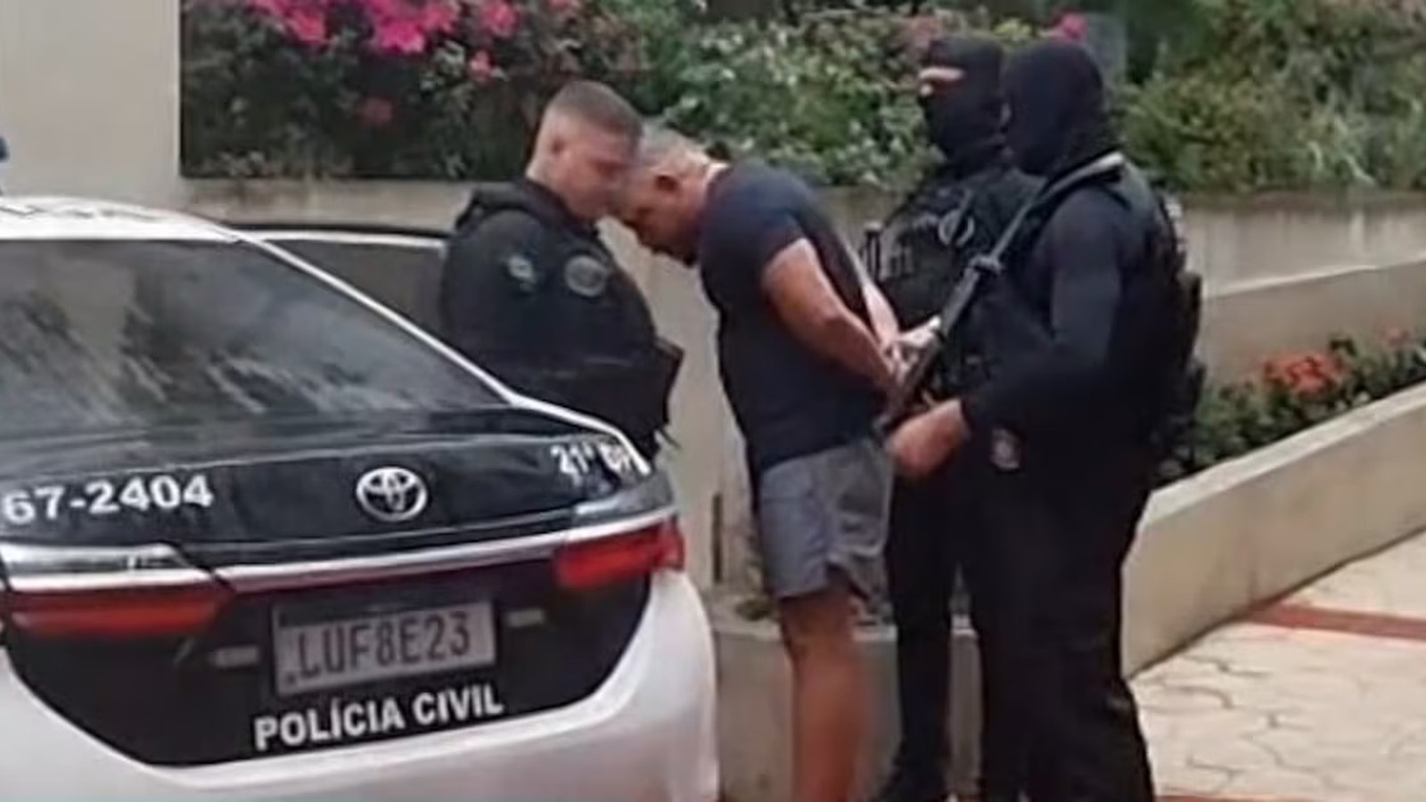 Homem algemado por três policiais ao lado de viatura Polícia Civil, placa LUF8E23
