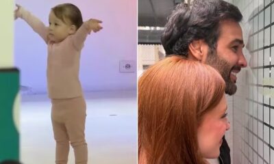 Menina de rosa dançando; casal sorridente, homem e mulher ruiva, olhando parede quadriculada