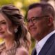 Mulher loira sorridente e homem de óculos sorrindo em um close-up ao ar livre