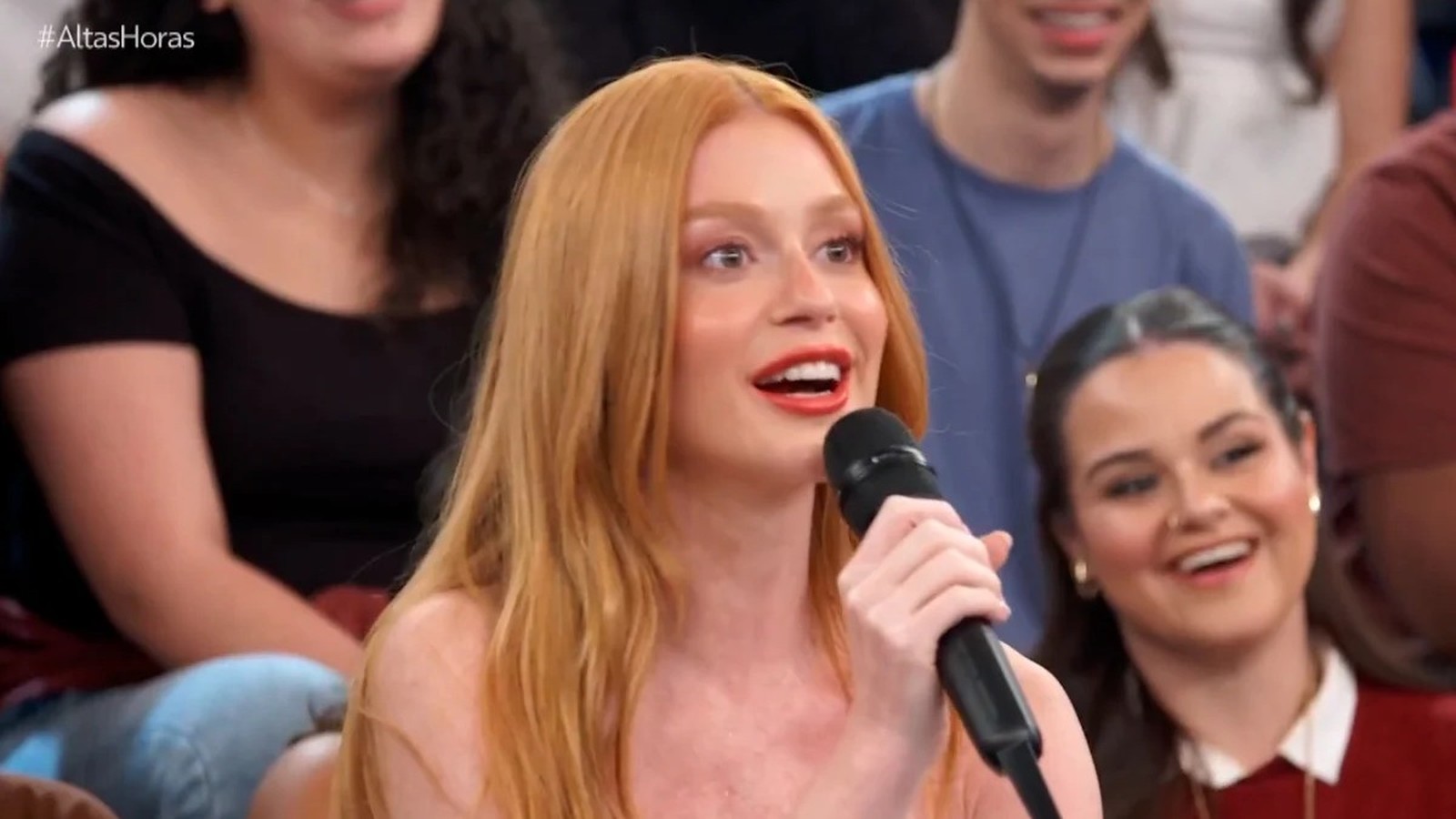 Atriz Marina Ruy Barbosa de cabelo ruivo falando em microfone, sorrindo