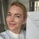 Lindsay Lohan sorrindo, segurando roteiro "Return to You" com seu nome em marca d'água.