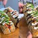 Sushi dogs fritos e empanados, com salmão, cream cheese, molho tarê, cebolinha e gergelim
