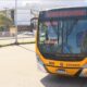 Ônibus amarelo BRT com letreiro "ROCKINRIO" e símbolo de acessibilidade parado em terminal