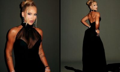 Mulher loira em vestido preto de gala, com top transparente, posa de frente e de costas