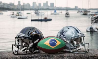 Capacete dos Ravens, capacete dos Cowboys e bola com bandeira do Brasil na orla