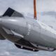 Drone submarino cinza Dive-LD com hélice traseira sendo içado sob céu nublado
