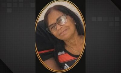 Mulher idosa, de óculos, com cabelo escuro e camisa preta com logo BRB, sorrindo