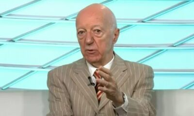 Claudio Carsughi, homem careca de terno listrado, gesticula em estúdio de TV